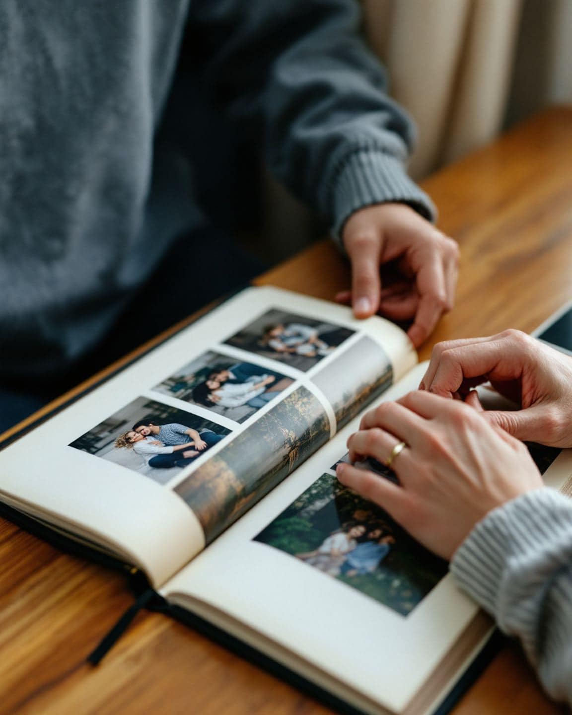 Hands turn the page of a family photo album.